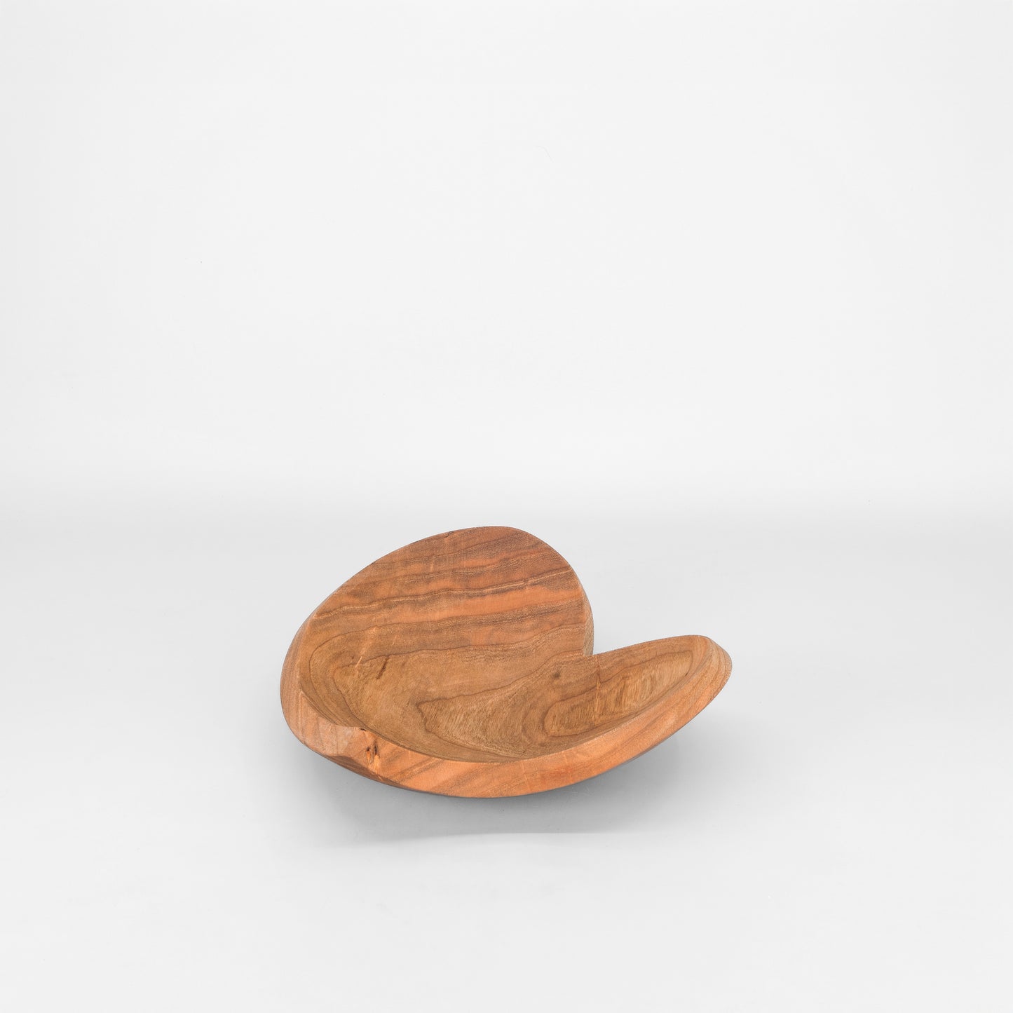 Heart shaped wooden bowl on light grey background