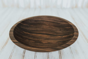 A shallow yet large wooden plate made from walnut.