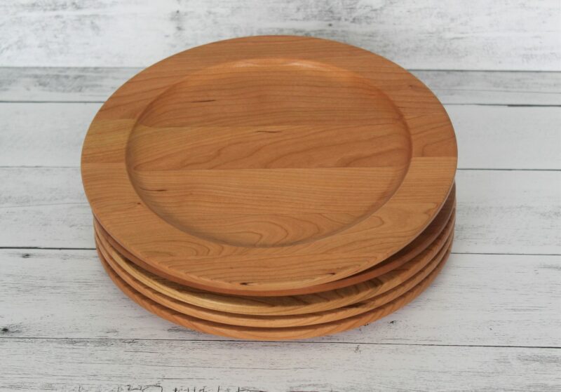 A stack of four cherry wood plates handcrafted by the Holland Bowl Mill.