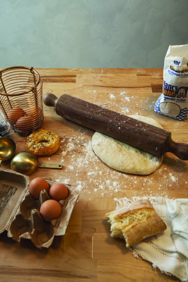A Shaker designed wooden rolling pin sits on top of a dough ball ready to be rolled into a crust.