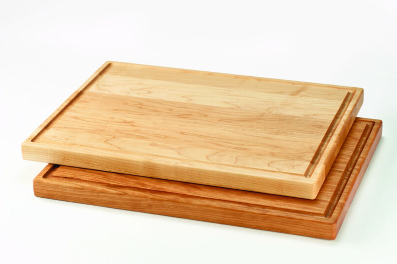 A stack of Maple and Cherry wood juice groove cutting boards made by the Holland Bowl Mill.