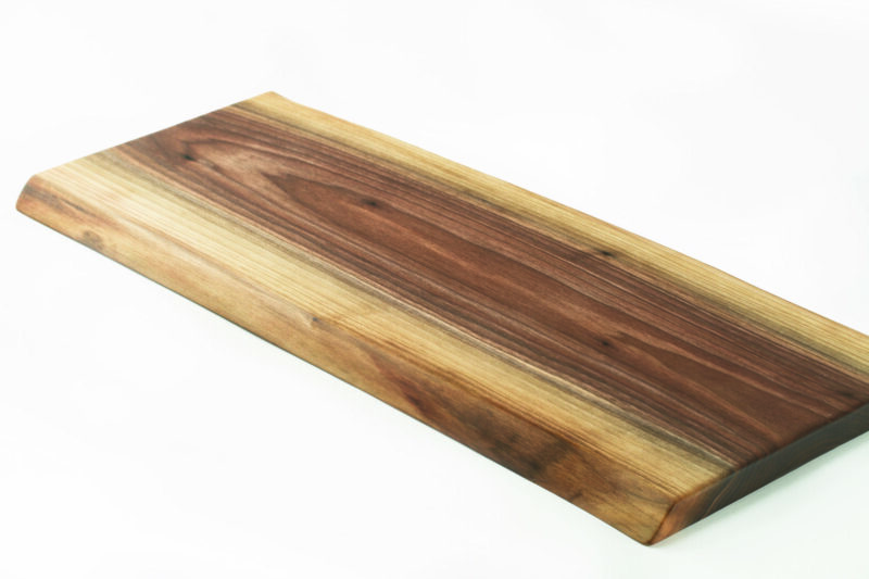 A double live edge wood cutting board with a rustic, deep, saturated wood grain.