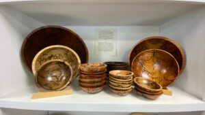 A shelf displaying multiple wooden bowls of various size and color.